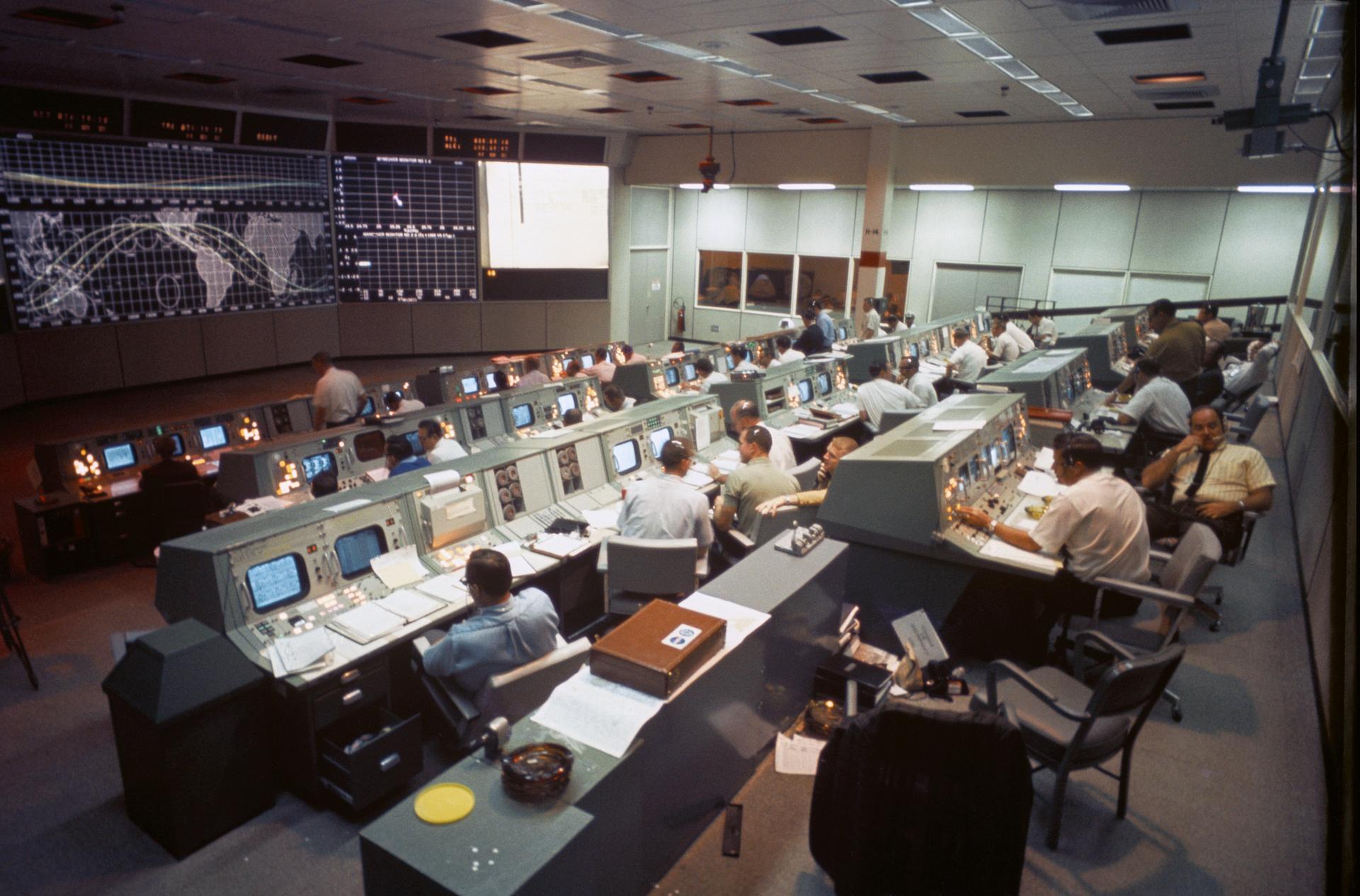 Public domain NASA photograph of a mission control room filled with operators and display consoles.